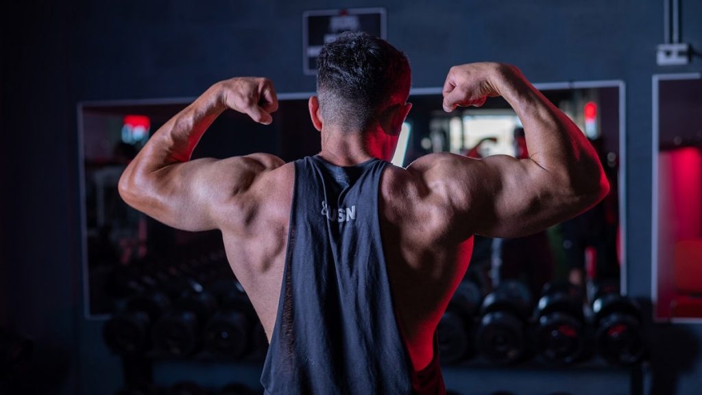 A man flexing his muscles in a gym
