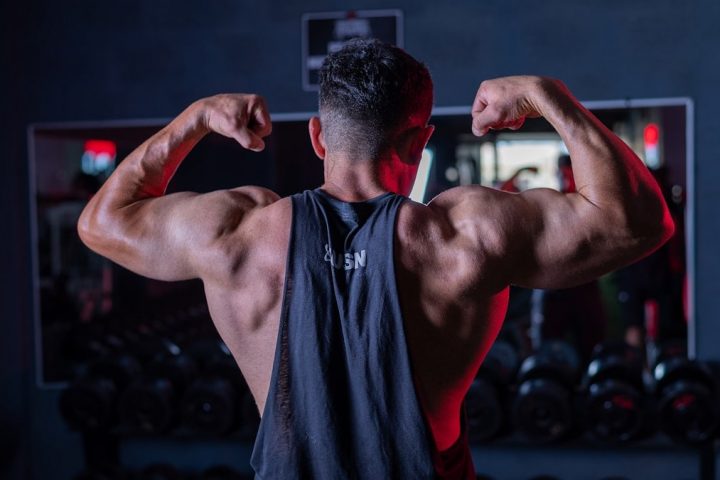 A man flexing his muscles in a gym